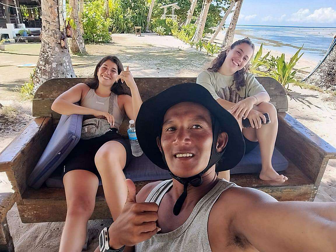 Un moniteur et deux élèves sur un banc de plage après un cours