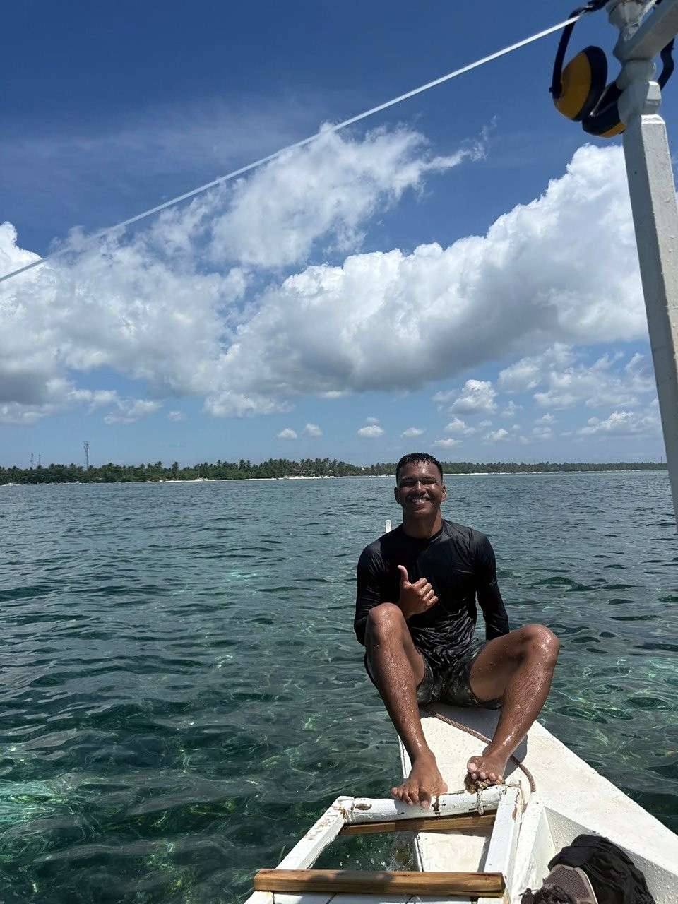 Un shaka depuis la proue du bateau, eau claire et l'île en fond
