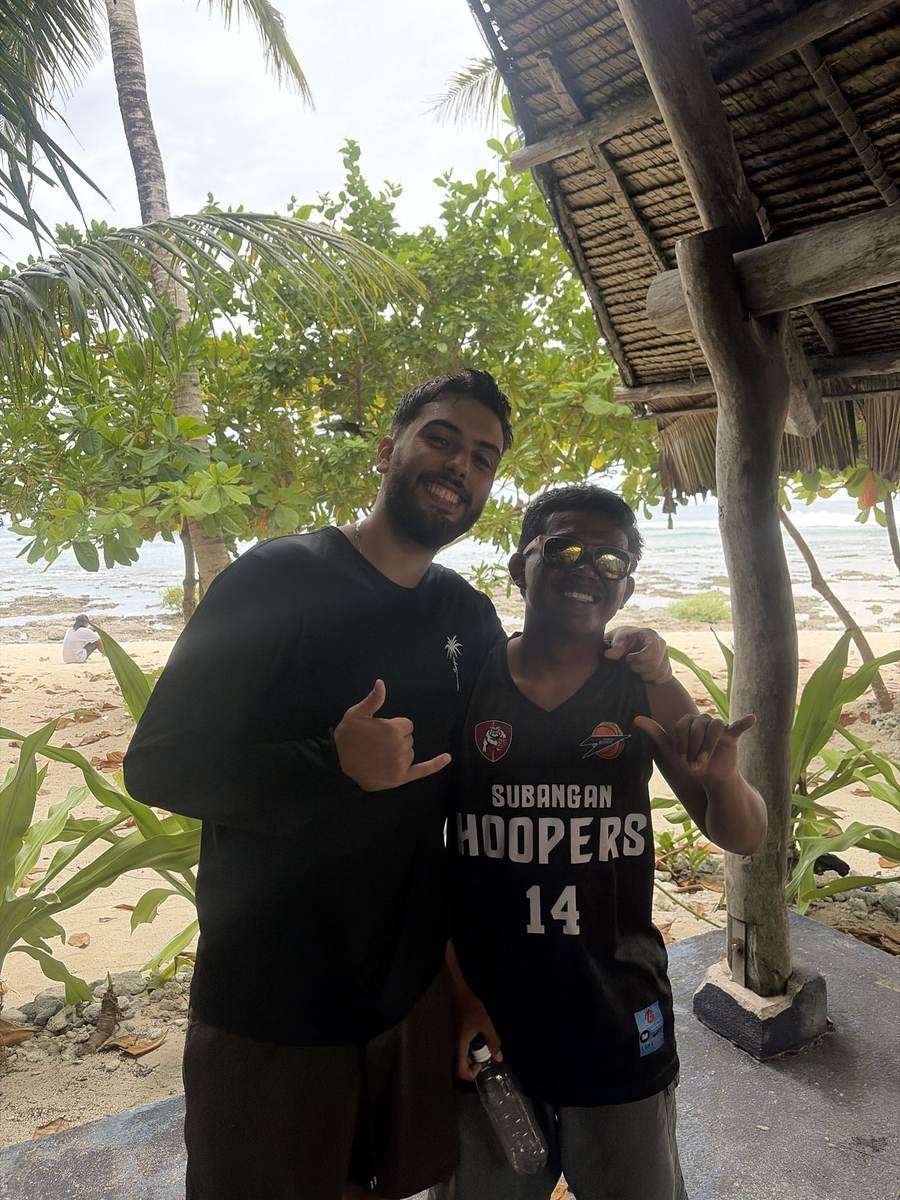 Francis, moniteur de surf de Surfing Sirago (à droite, avec des lunettes de soleil), avec un surfeur sur la plage à Siargao