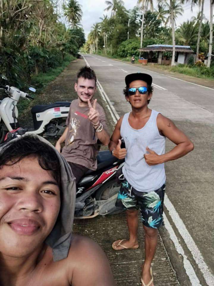 Selfie au bord de la route à Siargao : surfeurs, scooters et route bordée de palmiers