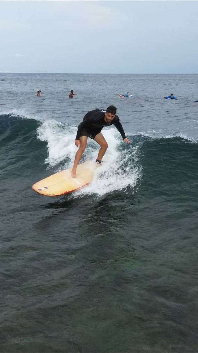 Un surfeur sur une droite, une gerbe d'eau derrière la planche