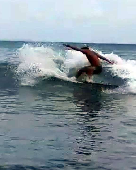 Surfeur qui tourne dans l'écume, par un matin gris
